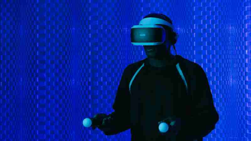 A man wearing a VR headset and using controllers immersed in a futuristic setting., tags: de en digitale kunst visuele - pexel